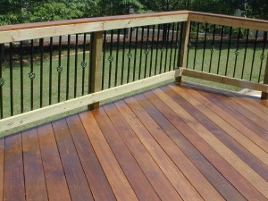 Ipe deck in Fortsyth GA with wooden rail and metal pickets with basket motif and Ipe cap